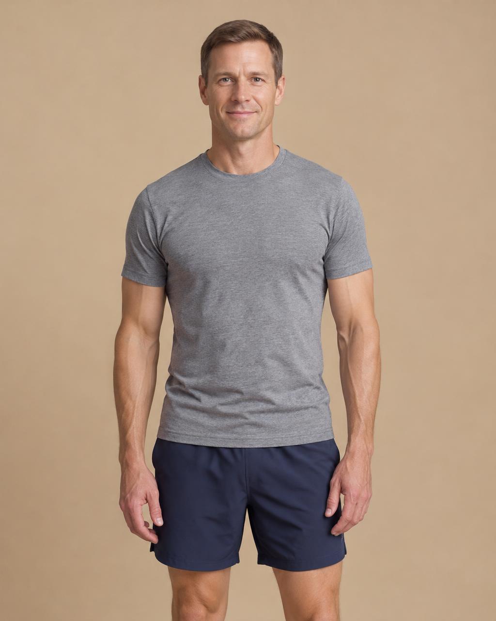 Man in a gray t-shirt standing facing the camera with hair and upper body visible
